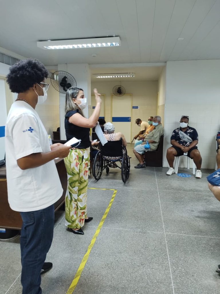 Dois colaboradores do multicentro ministram palestra em uma das salas de espera da unidade.